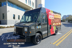 black and red food truck with philly cheese steak sandwich graphic on the side