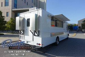 3/4 rear and side view of white food truck showing back door and open side service window