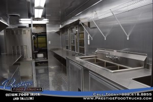 food truck interior with sinks, shelving and service window