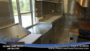 food truck interior with food prep table, service window and sinks