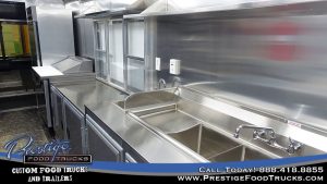 food truck interior with sinks, service window and food prep table