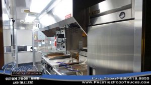 food truck interior with fryers, grill and exhaust hood