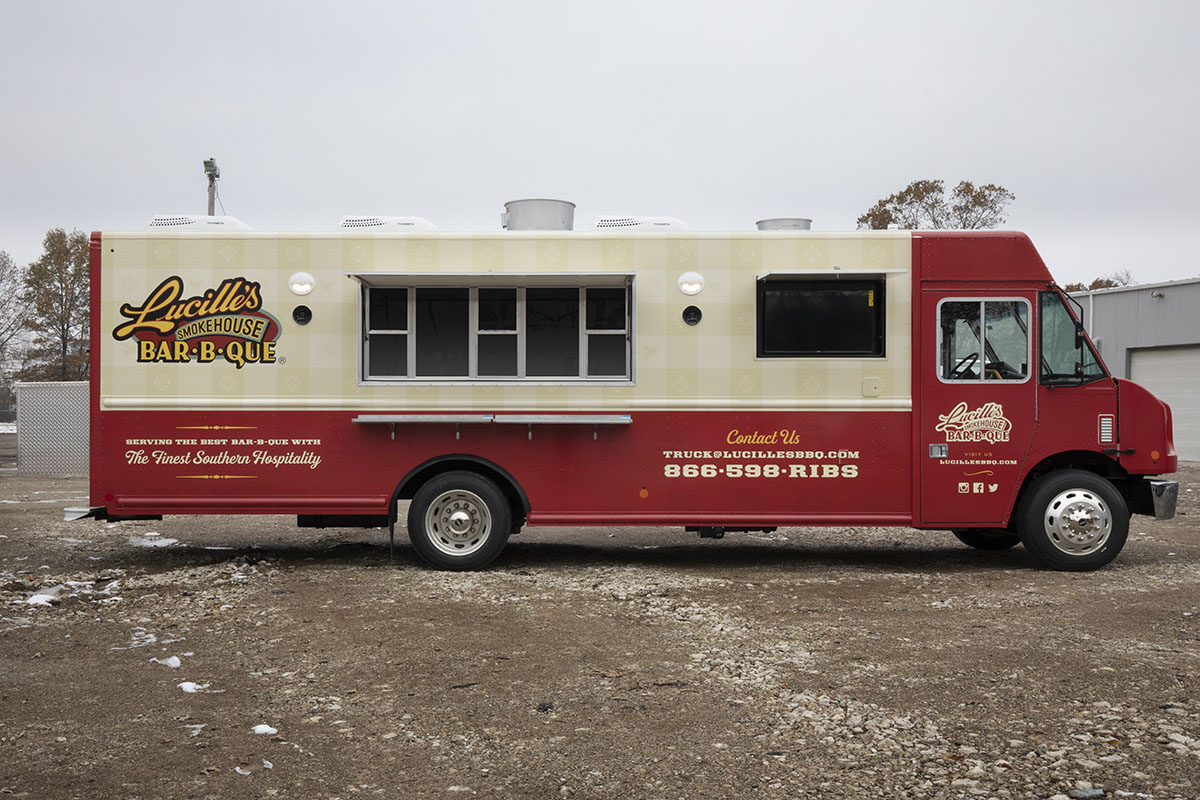 passenger side photo of a red and cream colored food truck with serving windows open