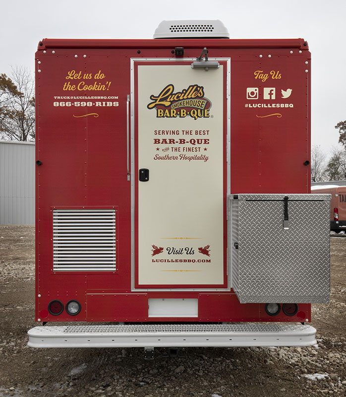rear view photo of a red and cream colored food truck with back door closed