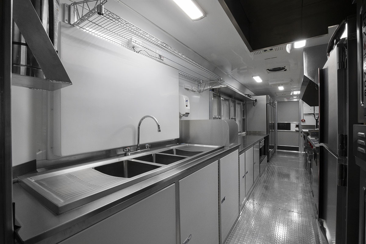 food truck interior kitchen photo showing sink, counter and fridges