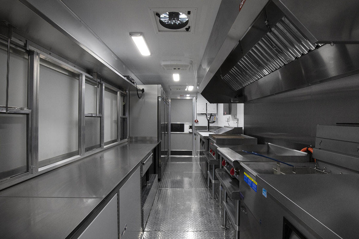 food truck interior kitchen photo showing counter, griddle, fridges and exhaust hood