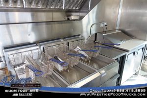food truck interior with fryer baskets and sandwich prep table