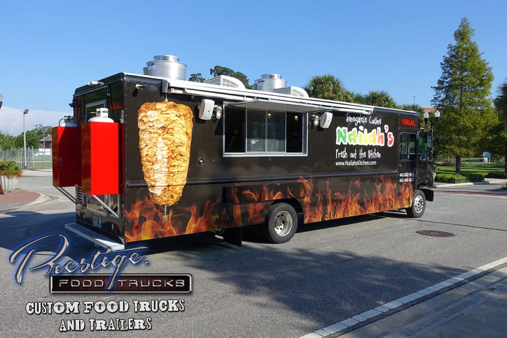 side/rear view of black food truck with graphics of flames and a rotisserie style meat roasting spit
