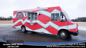 exterior photo of a food truck called Lexie's burger bus with pink and white chevron pattern graphics