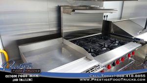 photo of a grill top and stove inside a food truck