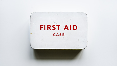 photo of an old white metal box that says First Aid Case in red letters