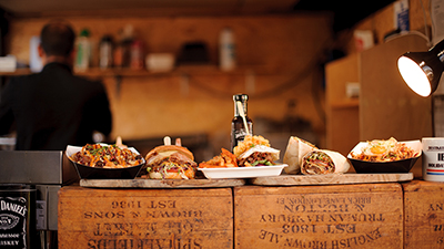 photo of wooden serving boards full of pub-style food on the counter in a rustic restaurant