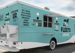 teal and white coffee food truck parked on a sunny day