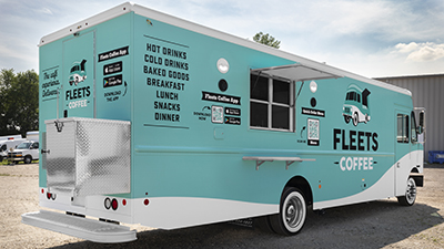 teal and white coffee food truck parked on a sunny day
