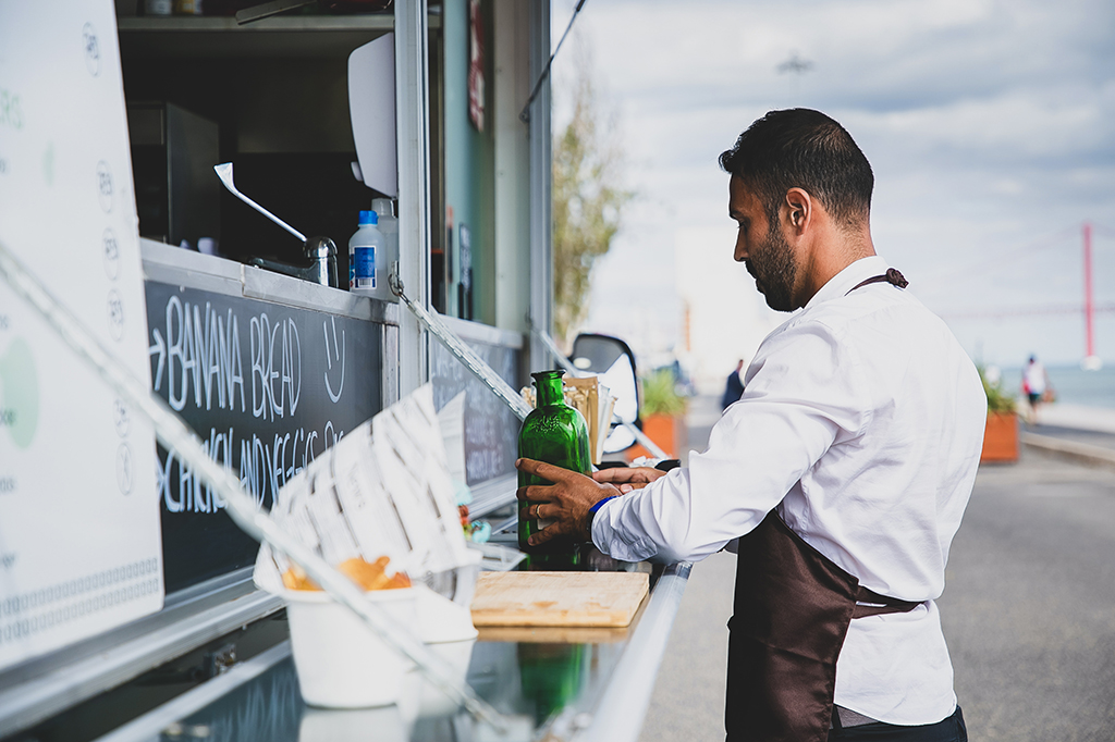photo of a worker setting items on a food truck's fold down shelf