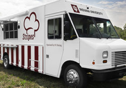 white and red food truck parked on grass