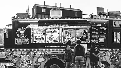 three women ordering from a food truck