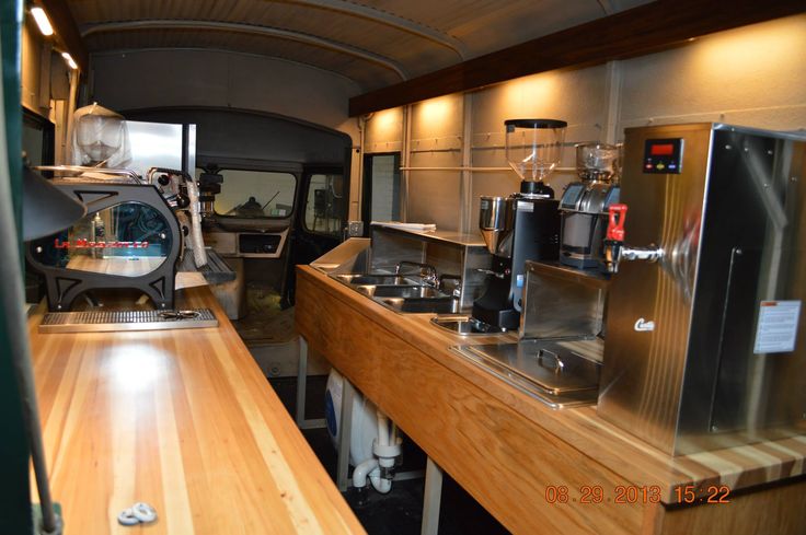interior of food truck with wooden counters, espresso and coffee machines, sinks and other appliances.